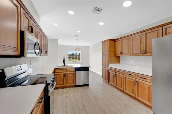 a kitchen with stainless steel appliances granite countertop a sink and a refrigerator