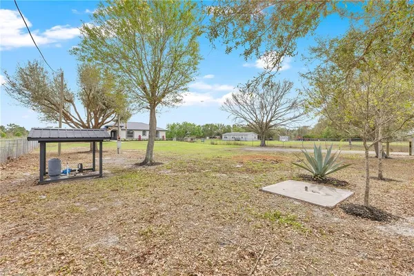 a backyard of a house with table and chairs