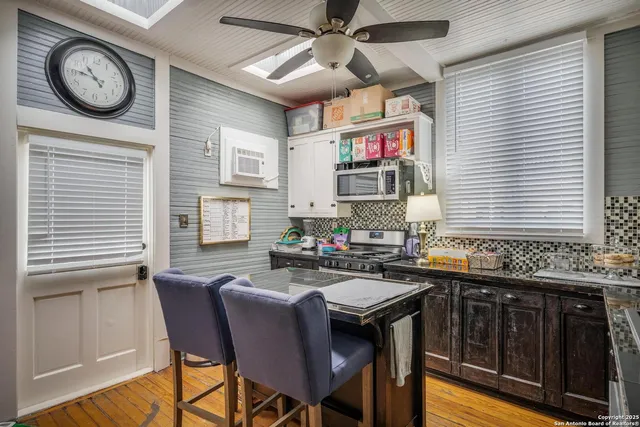 a kitchen with a table chairs cabinets and a window