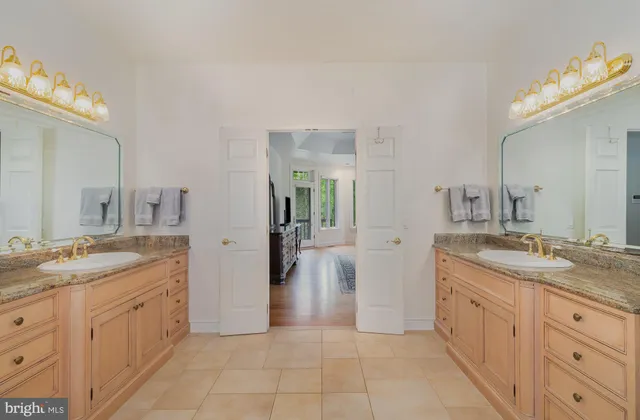 a bedroom with a bed a dresser and a chandelier