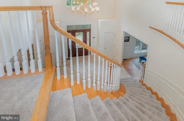 a bedroom with a bed a dresser and a chandelier