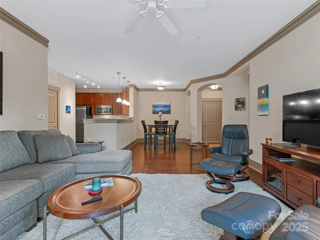 a living room with furniture a dining table and a flat screen tv