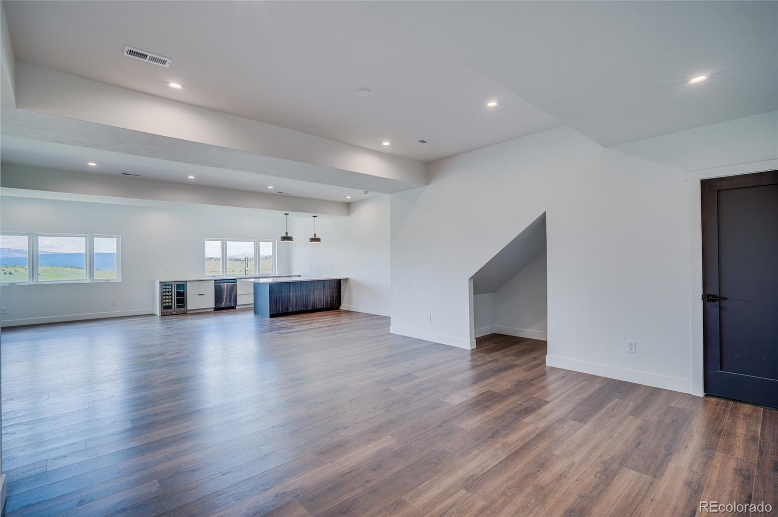 561 Upper Ranch View Drive Granby, CO 80446 - Photo 24 of 44 an empty room with wooden floor and windows