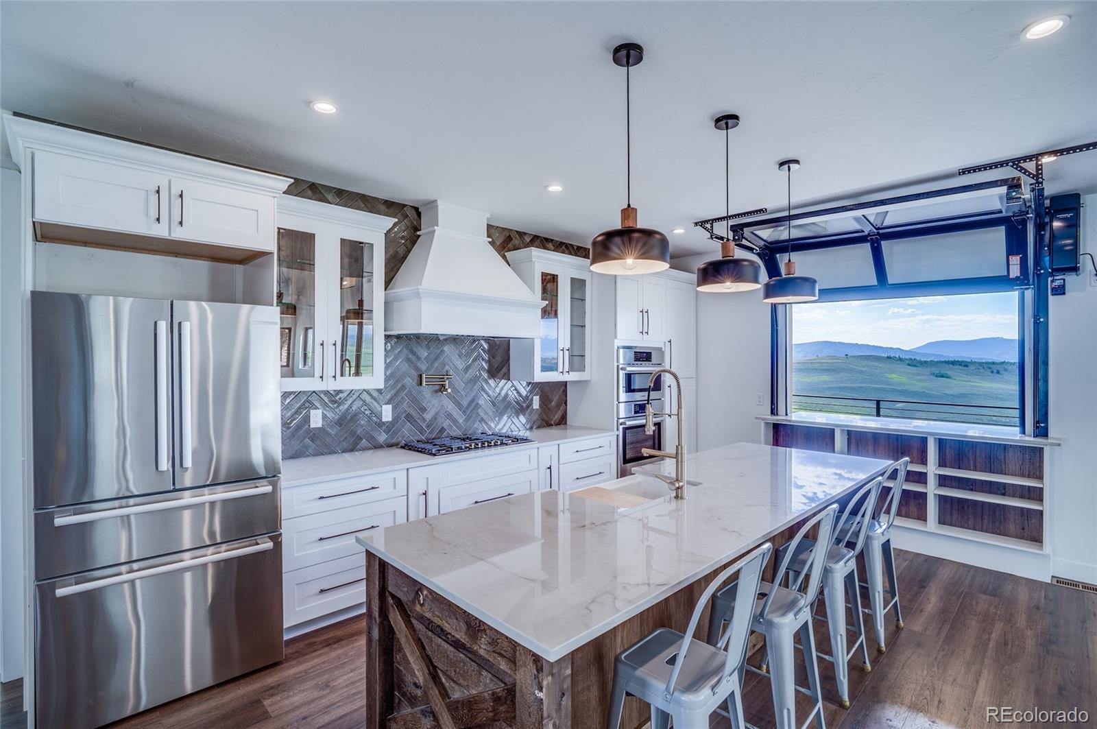 561 Upper Ranch View Drive Granby, CO 80446 - Photo 6 of 44 a kitchen with stainless steel appliances a dining table chairs and wooden floor