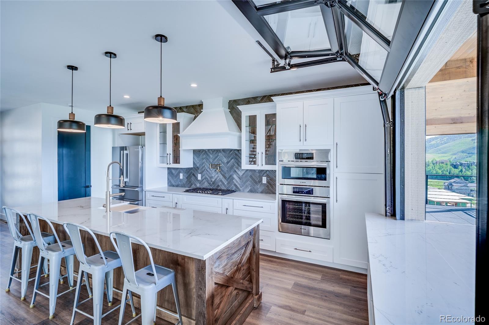 561 Upper Ranch View Drive Granby, CO 80446 - Photo 7 of 44 a kitchen with stainless steel appliances kitchen island granite countertop a stove a sink and a refrigerator