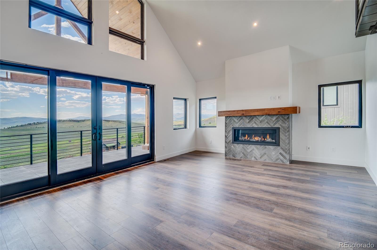 561 Upper Ranch View Drive Granby, CO 80446 - Photo 10 of 44 a view of empty room with wooden floor and fireplace