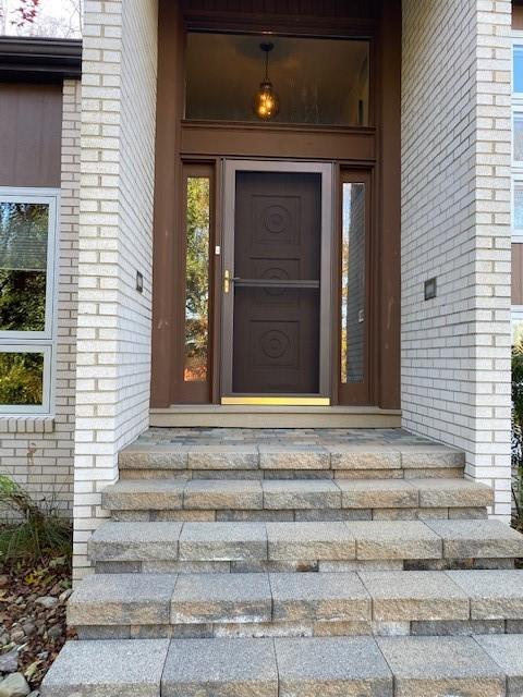 Entry way with omni-stone sidewalk leading to 3 season sun room and great outdoor patio area