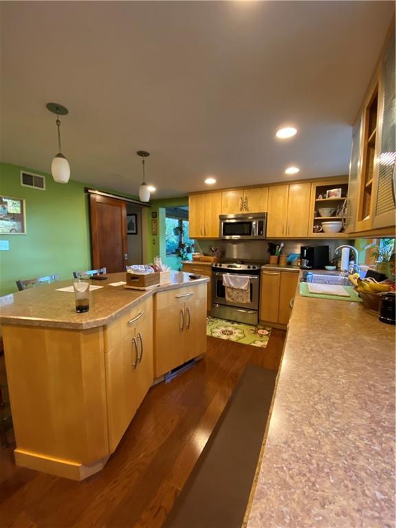 Kitchen with loads of cabinets and lighter wood tones.