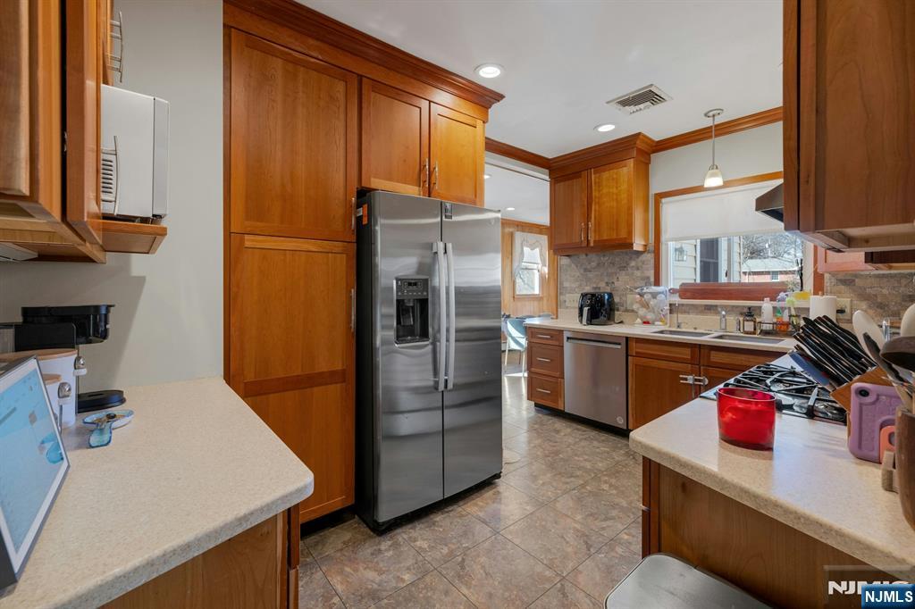 120 Meadowbrook Road Livingston, NJ 07039 - Photo 14 of 36 a kitchen with stainless steel appliances a refrigerator a sink a stove and cabinets