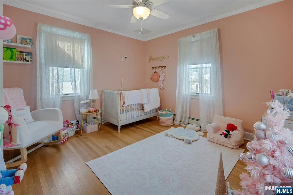 120 Meadowbrook Road Livingston, NJ 07039 - Photo 20 of 36 a bedroom with a baby bed a couch and two large window