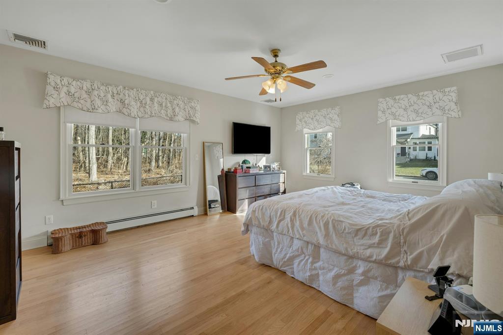 120 Meadowbrook Road Livingston, NJ 07039 - Photo 28 of 36 a spacious bedroom with a bed and a flat screen tv