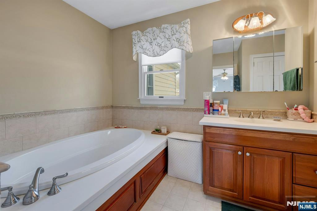 120 Meadowbrook Road Livingston, NJ 07039 - Photo 30 of 36 a bathroom with a tub sink and a mirror
