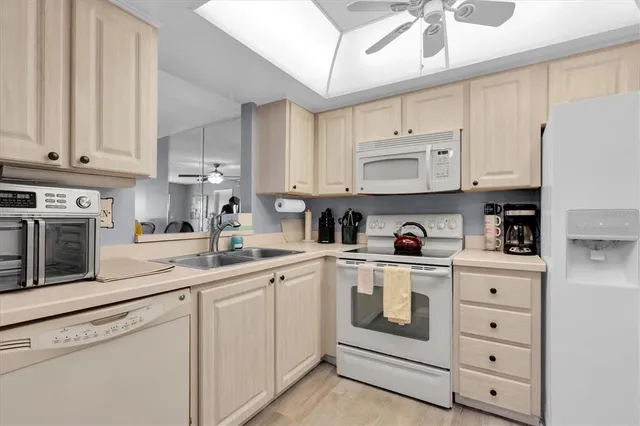 a kitchen with white cabinets and white appliances
