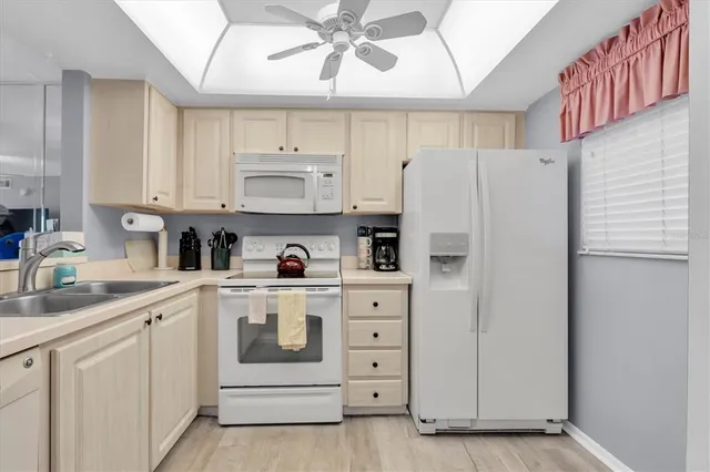 a kitchen with white cabinets and white appliances