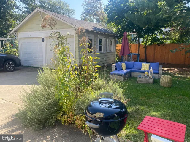 a view of a backyard with table and chairs potted plants and a fire pit