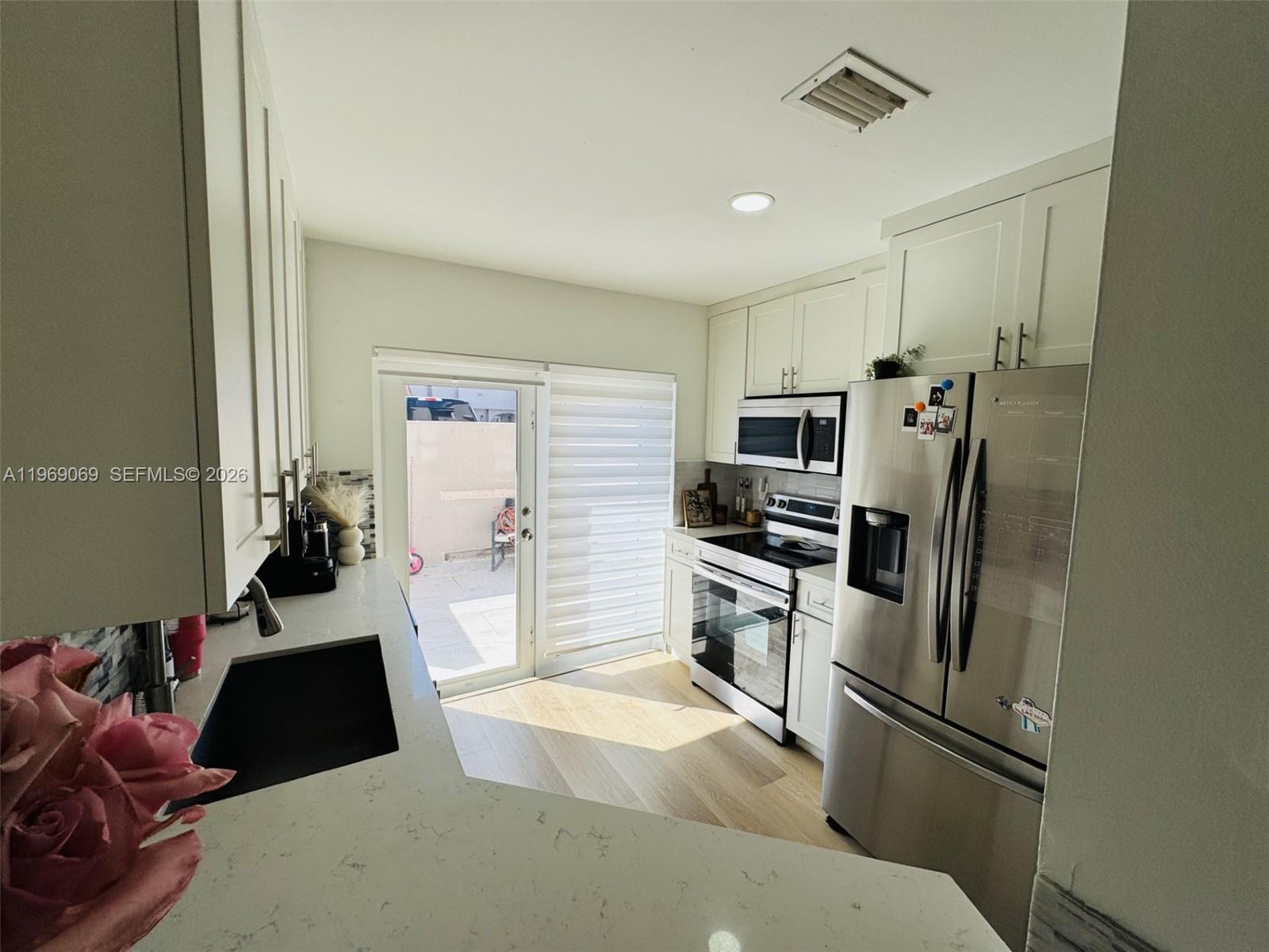 12853 Southwest 64th Lane Miami, FL 33183 - Photo 4 of 13 a kitchen with a refrigerator and a sink