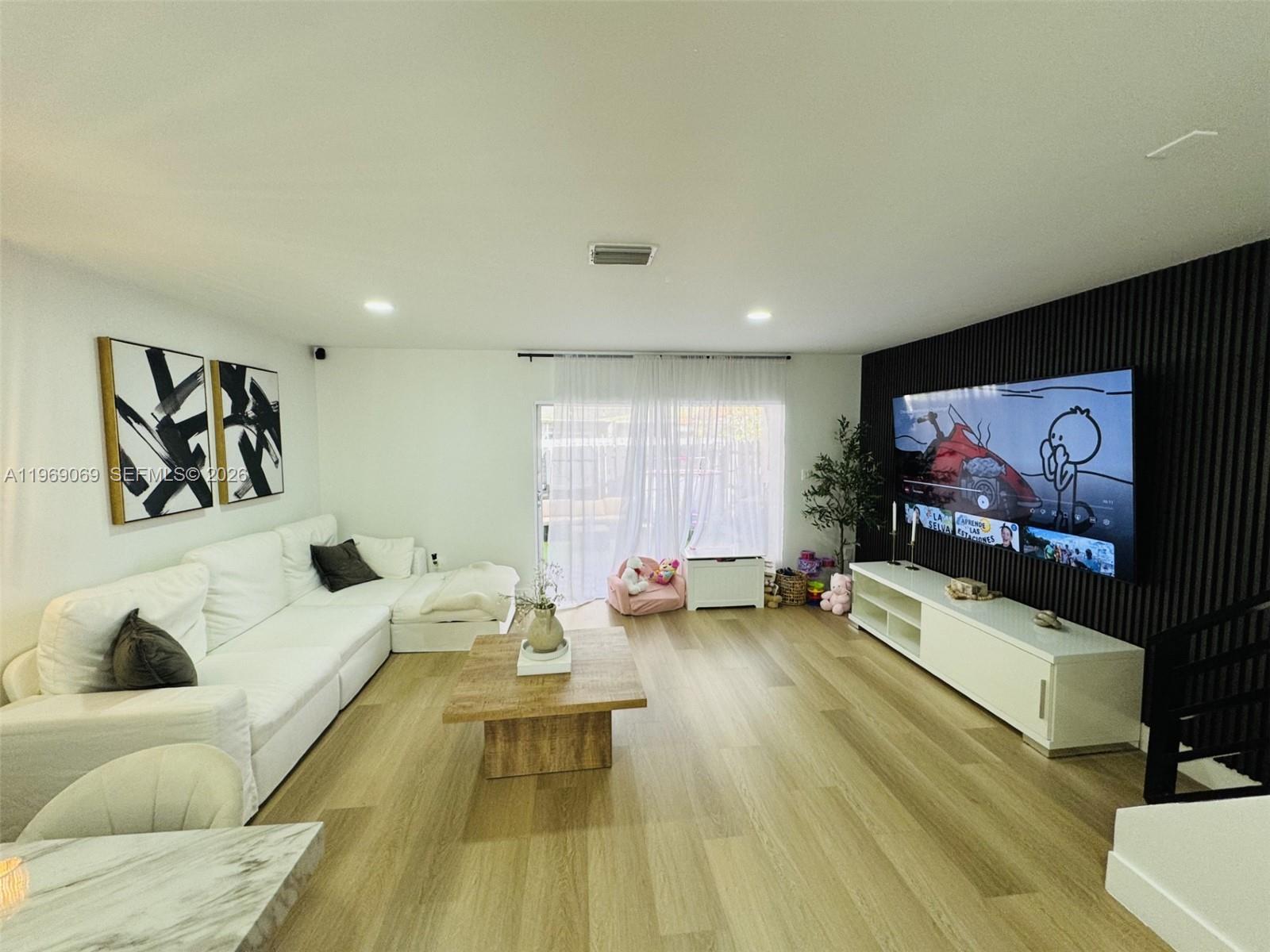 12853 Southwest 64th Lane Miami, FL 33183 - Photo 5 of 13 a living room with furniture and a flat screen tv