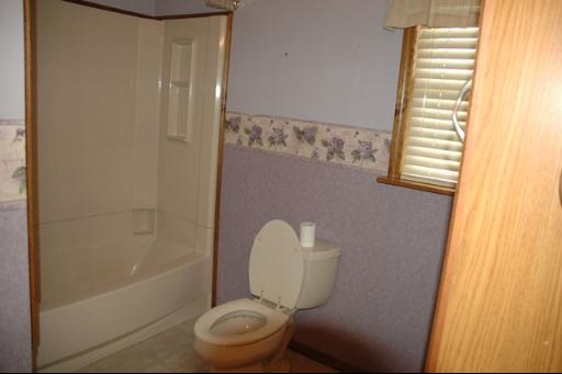 7868 South Sugar Island Road Chebanse, IL 60922 - Photo 8 of 12 a white toilet sitting next to a bath tub