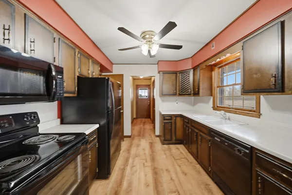 a kitchen with stainless steel appliances granite countertop a sink and wooden floors