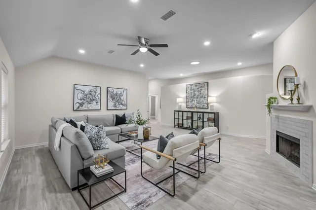 a living room with furniture a fireplace and a flat screen tv