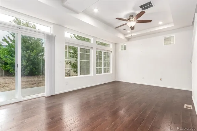 a view of an empty room with wooden floor and a large window