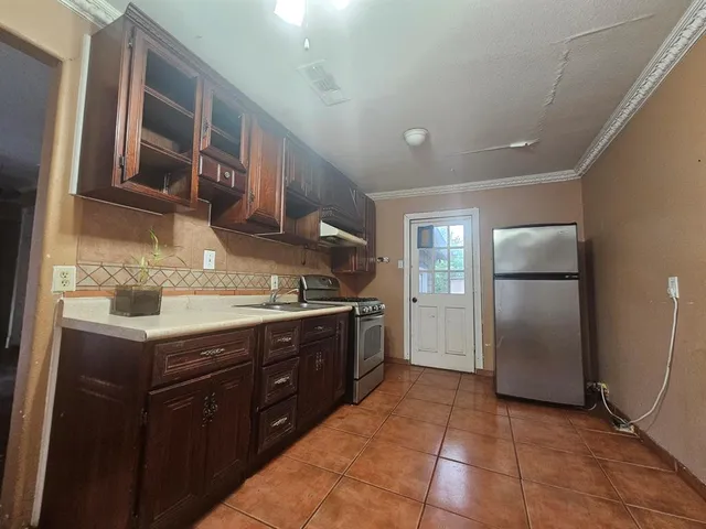a kitchen with a stove a cabinets and a wooden floor