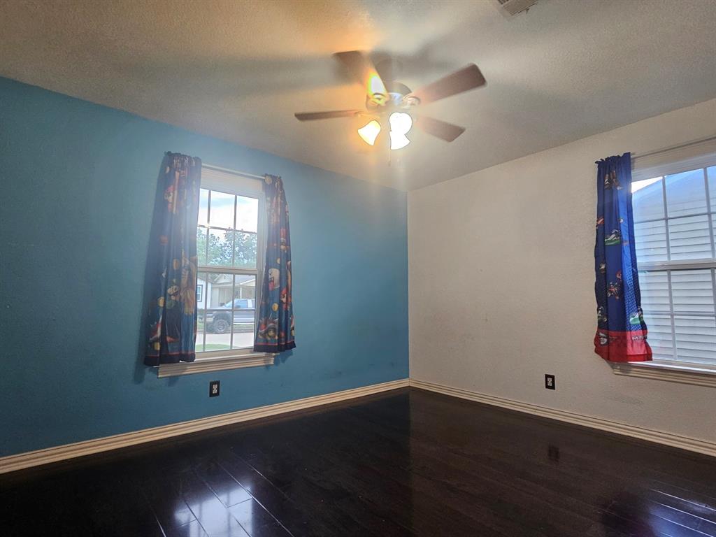 231 Elm Street Hurst, TX 76053 - Photo 6 of 11 a view of an empty room with wooden floor and a window