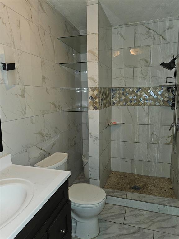 231 Elm Street Hurst, TX 76053 - Photo 7 of 11 a bathroom with a sink a toilet and shower