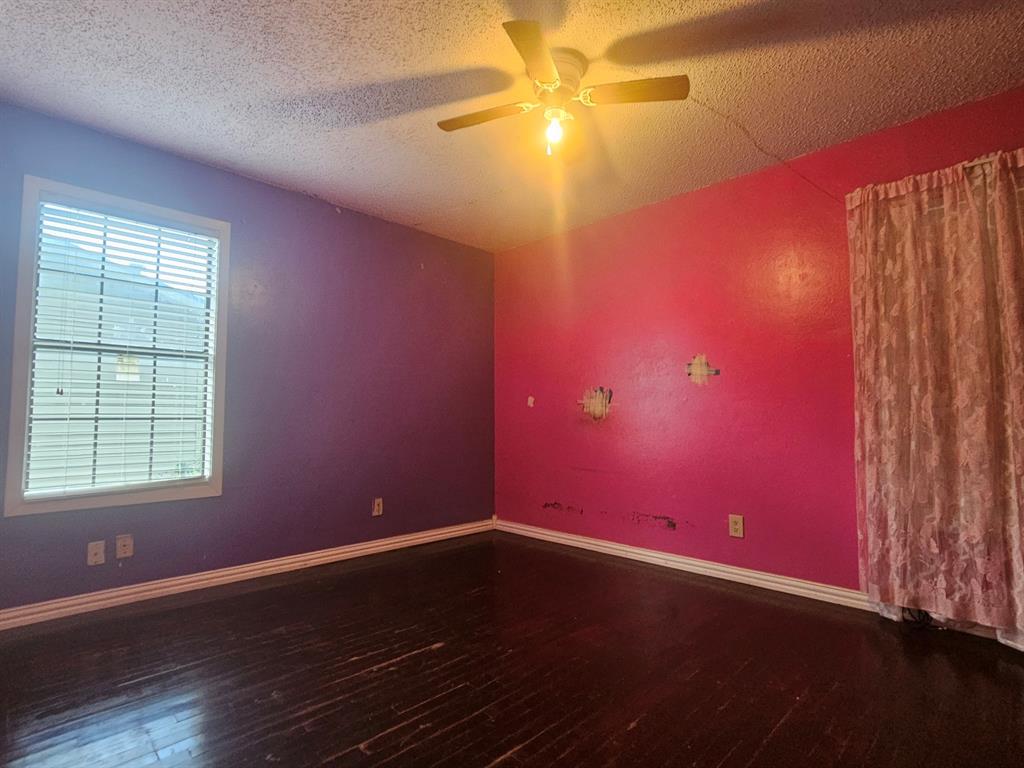 231 Elm Street Hurst, TX 76053 - Photo 8 of 11 an empty room with wooden floor and windows