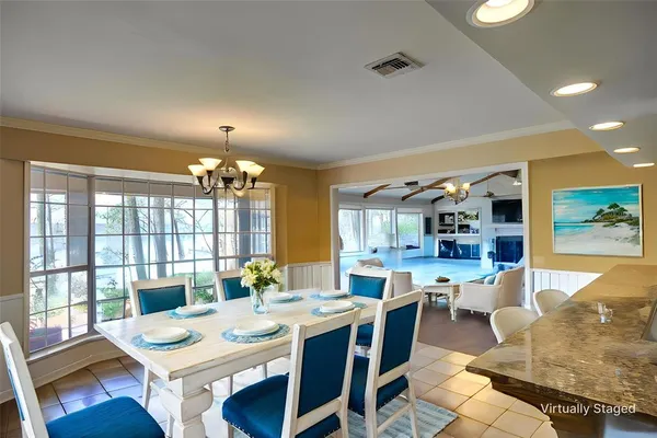 a large dining hall with stainless steel appliances granite countertop a dining table and chairs with wooden floor