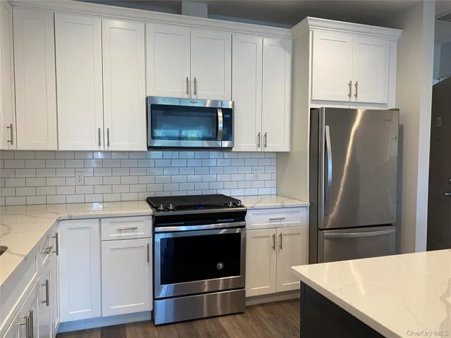 a kitchen with cabinets stainless steel appliances and a counter space