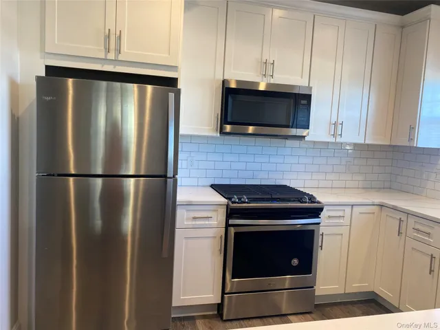 a kitchen with cabinets appliances and a window