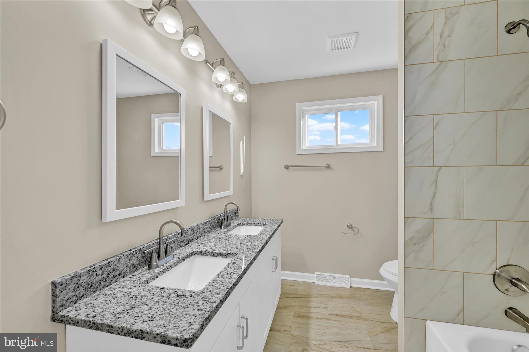 8117 Callo Lane Rosedale, MD 21237 - Photo 14 of 23 a bathroom with a granite countertop sink and a mirror