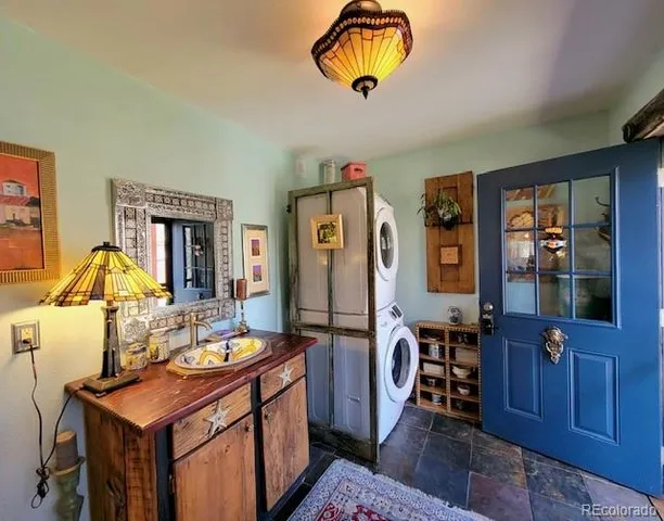 a living room with furniture a chandelier and kitchen view