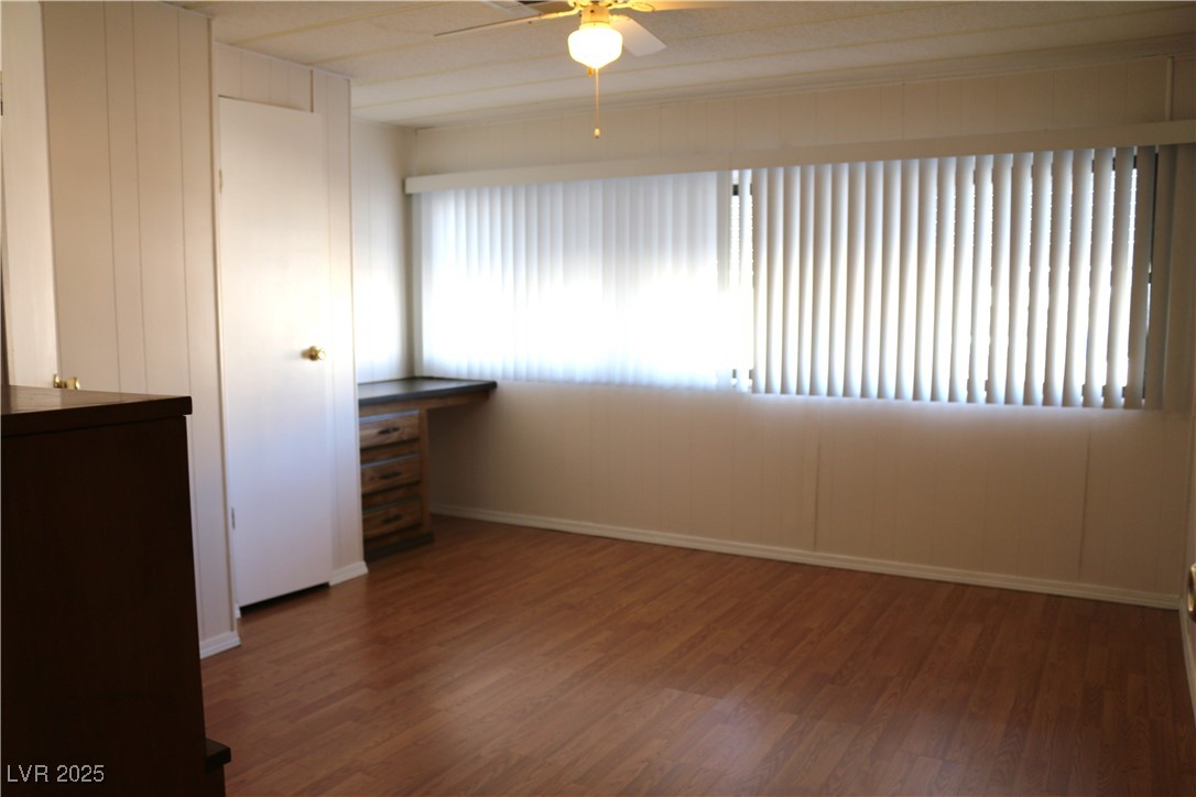 4633 Royal Ridge Boulevard Las Vegas, NV 89103 - Photo 8 of 13 Empty room with baseboards, ceiling fan, and wood finished floors