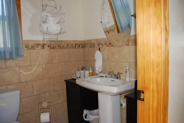 a bathroom with a sink and mirror with toilet