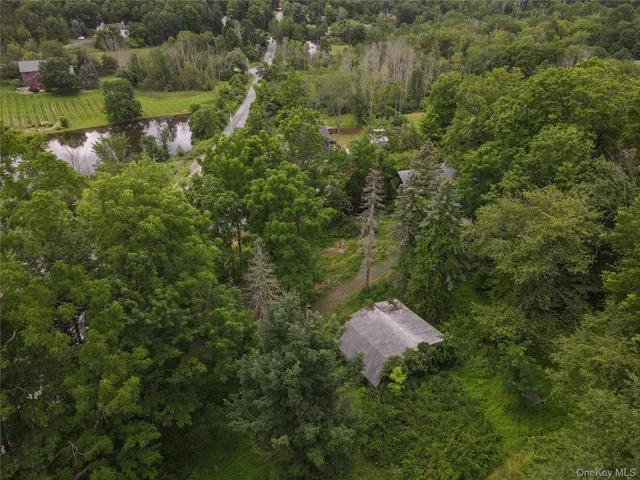 an aerial view of residential houses with outdoor space and trees
