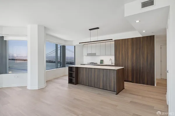 a large kitchen with a wooden floor and cabinets