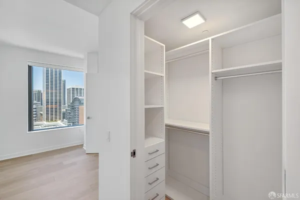 a view of an empty room with windows and closet