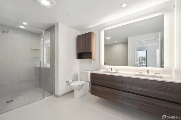 a bathroom with a double vanity sink toilet and shower