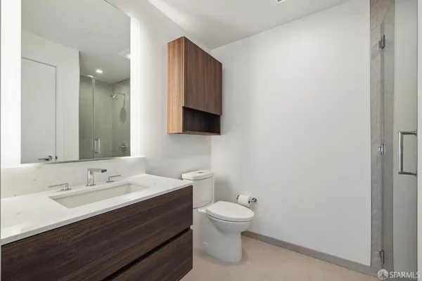 a bathroom with a sink a toilet and mirror