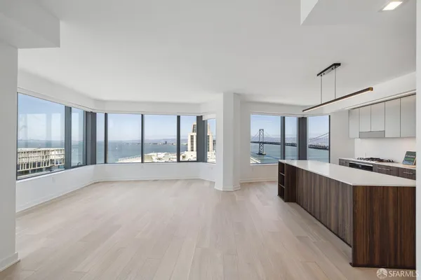 a large open kitchen with stainless steel appliances granite countertop a refrigerator a sink dishwasher a stove and white countertops with wooden floor