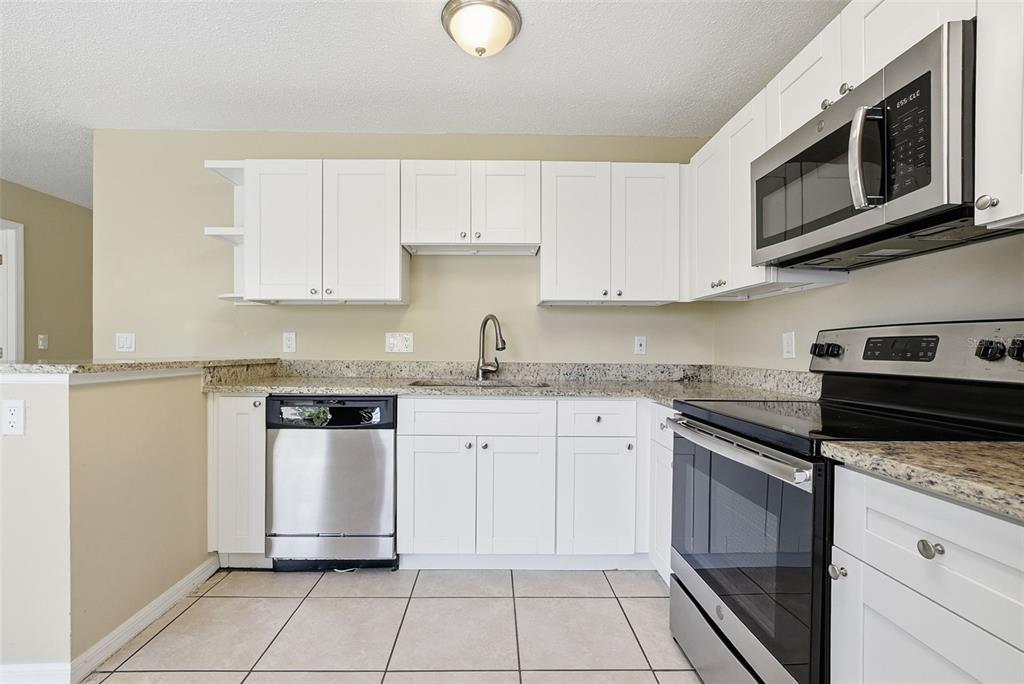 617 Greys Ferry Road Orlando, FL 32811 - Photo 14 of 35 a kitchen with cabinets stainless steel appliances and a sink