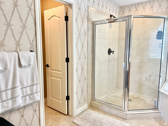 369 Culross Circle Tooele, UT 84074 - Photo 26 of 54 Glass-enclosed shower featuring light-toned tile walls and flooring, complemented by matte black fixtures
