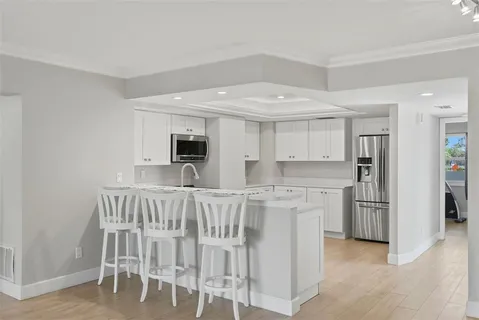 a kitchen with white cabinets and stainless steel appliances