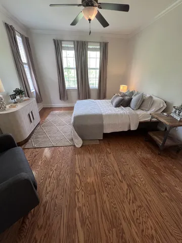 a spacious bedroom with a bed and wooden floor