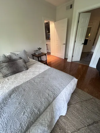 a bedroom with a bed and wooden floor