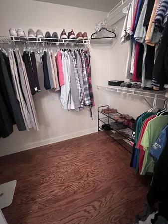 a view of walk in closet with clothes and shoes