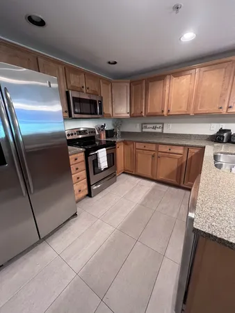 a kitchen with stainless steel appliances granite countertop a stove a sink and a microwave