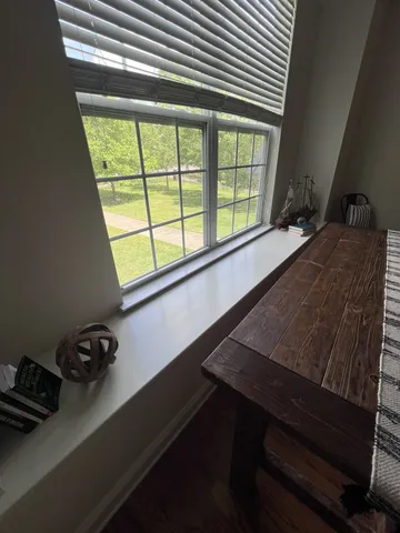 a view of a window with chair and table in a room